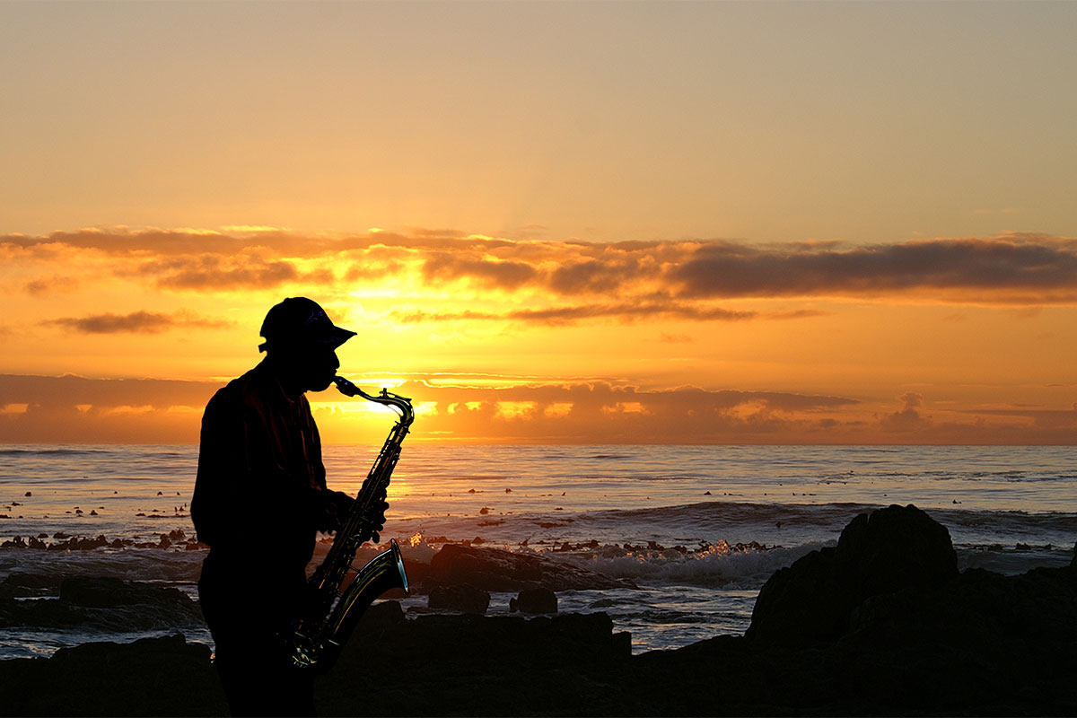 Saxophonspieler vor der Ostsee bei Sonnenuntergang während eines Jazzabends in der Arkona Sky Bar auf Rügen.